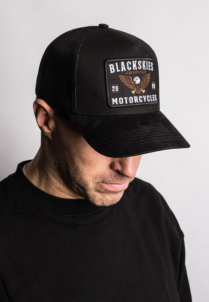 Person wearing a black cap with 'Blackskies Motorcycles' logo on a light gray background