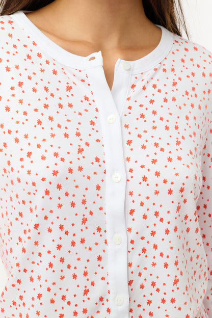 A woman wears the Roller Rabbit Étoiles Nessa Cardigan over a long-sleeve white pajama set with red polka dots, made from cozy Pima cotton in Peru, standing against a light background and looking at the camera with a relaxed expression.