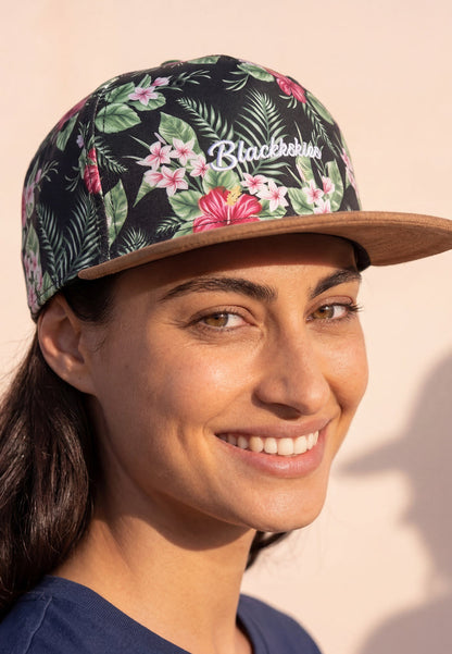 Woman wearing a floral-patterned cap with 'Blackstone' branding on a beige background