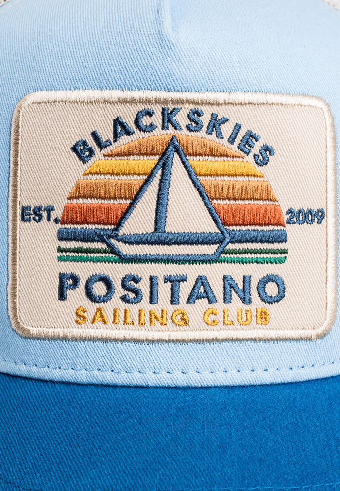 Patch on a blue cap with 'Blackskies Positano Sailing Club' design
