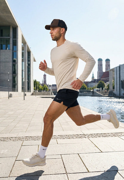Man running outdoors with a cityscape in the background