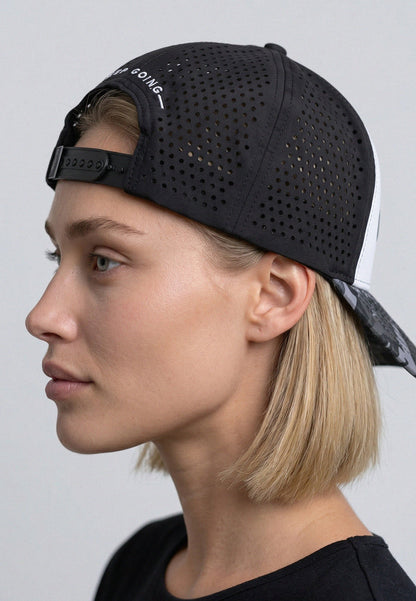 Person wearing a black perforated cap on a plain background