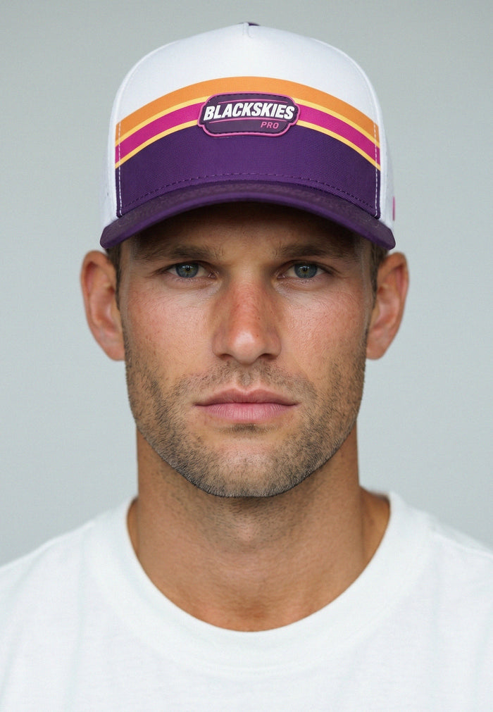 Man wearing a white and purple cap with 'Blackskies' branding on a gray background