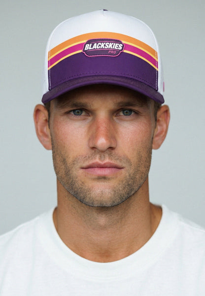 Man wearing a white and purple cap with 'Blackskies' branding on a gray background