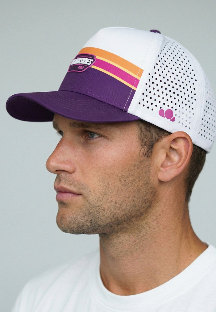 Man wearing a purple and white perfromance sport cap with colorful stripes on a gray background