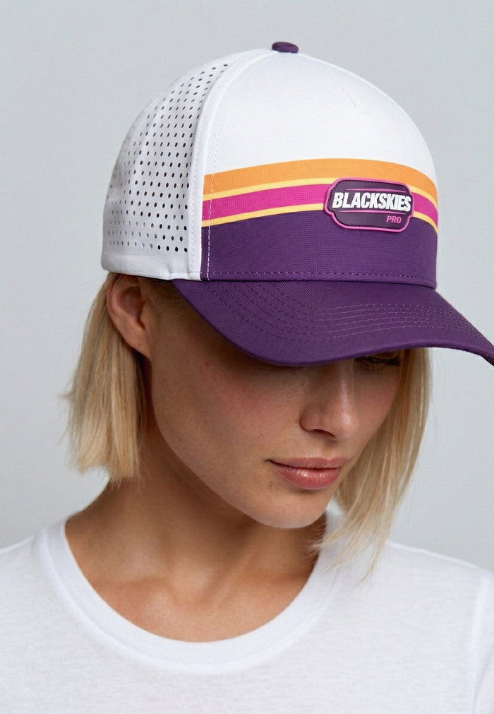 Person wearing a white and purple cap with colorful stripes and 'Blackskies' branding.