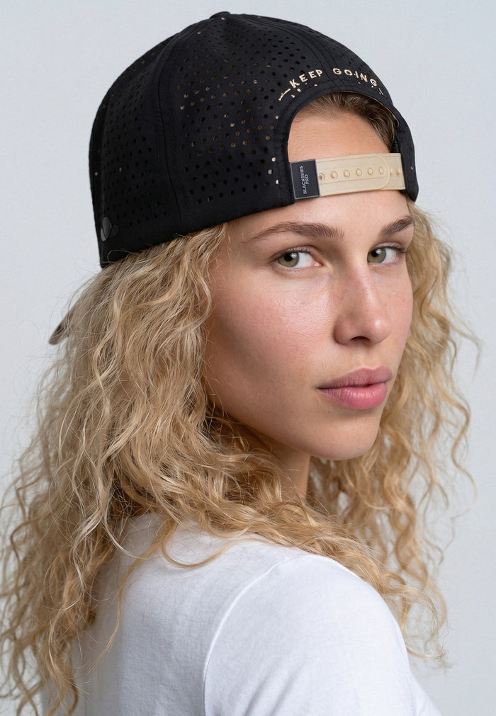Person wearing a black cap with text on a plain background