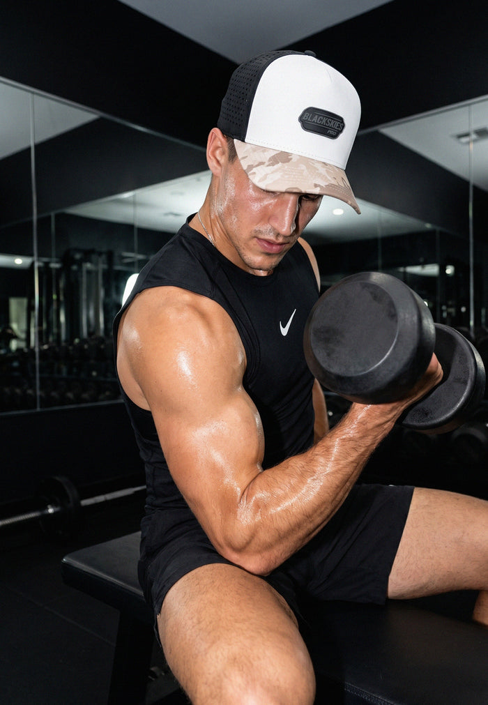 Muscular man exercising with dumbbells in a gym setting