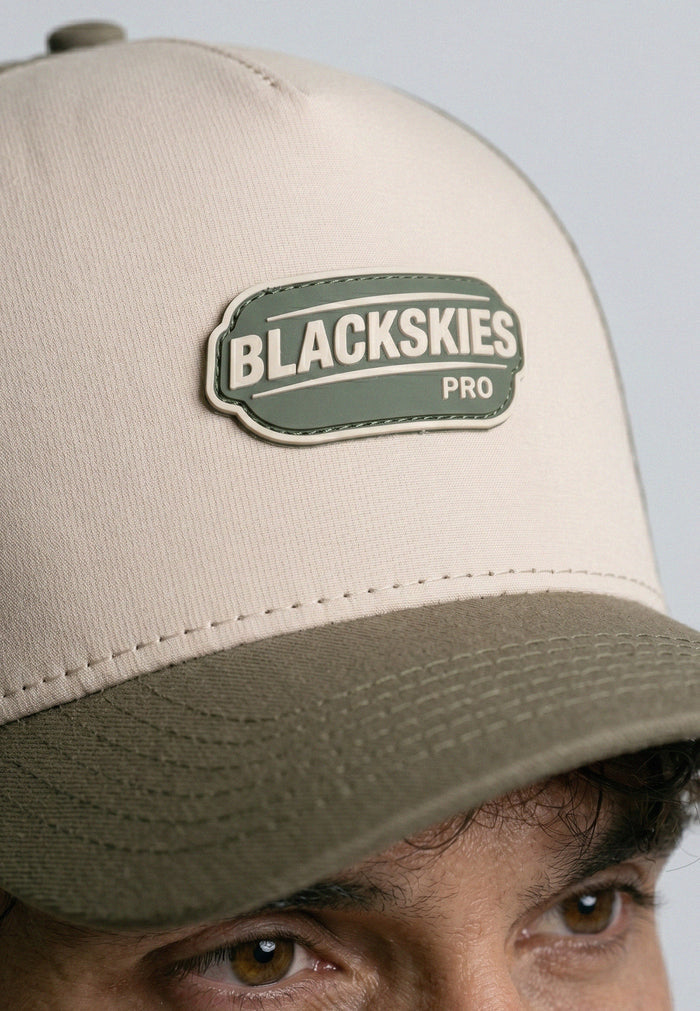 Beige cap with a 'Blackskies Pro' logo on a light gray background