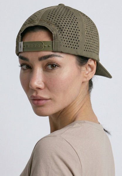 Woman wearing a green baseball cap on a plain background
