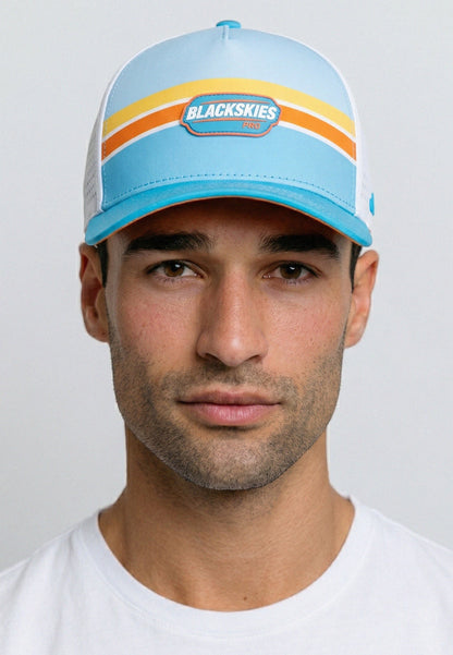 Man wearing a blue cap with 'Blackskies' branding against a light gray background