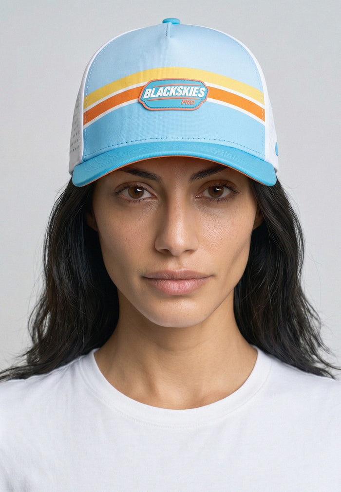 Person wearing a blue cap with a visible brand logo against a plain background