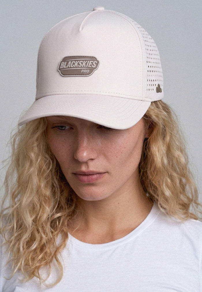 Person wearing a beige cap with 'Blackskies Pro' logo on a plain background