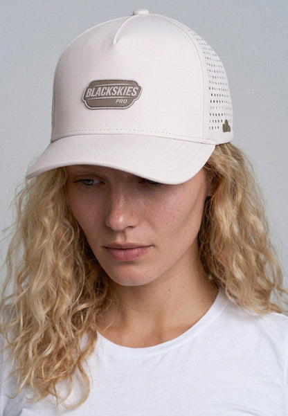 Person wearing a beige cap with 'Blackskies Pro' logo on a plain background