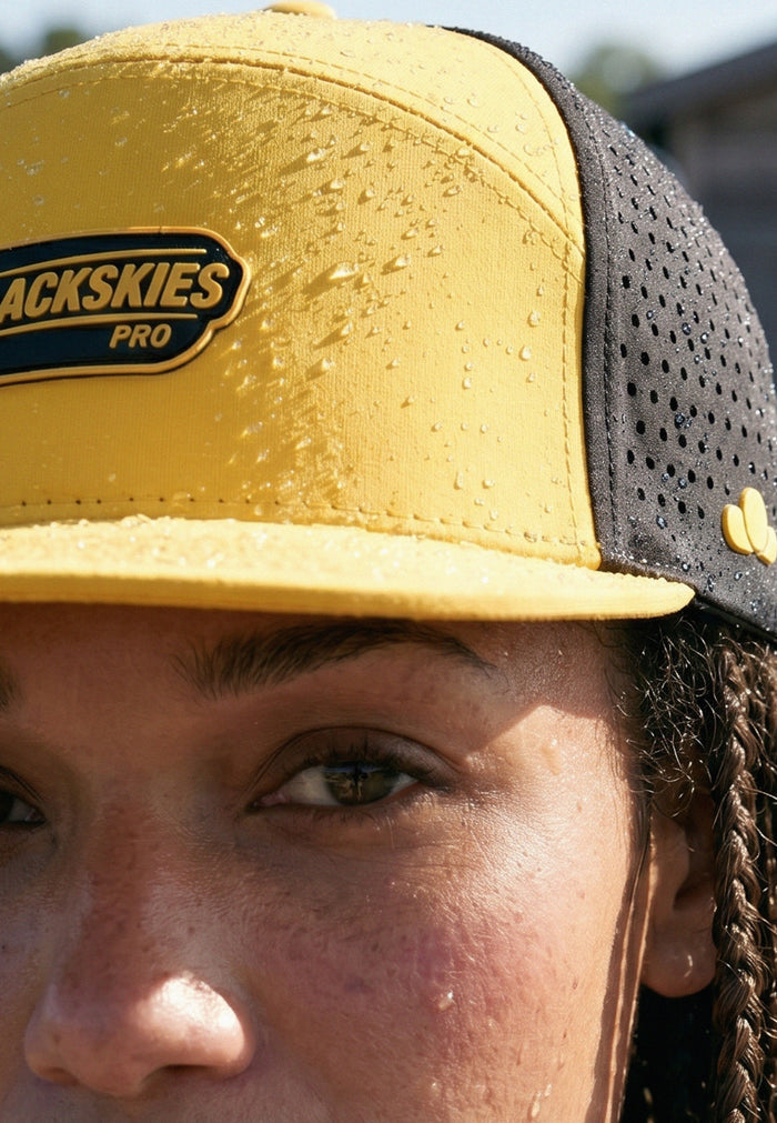 Person wearing a yellow and black cap with 'Backskies Pro' branding.
