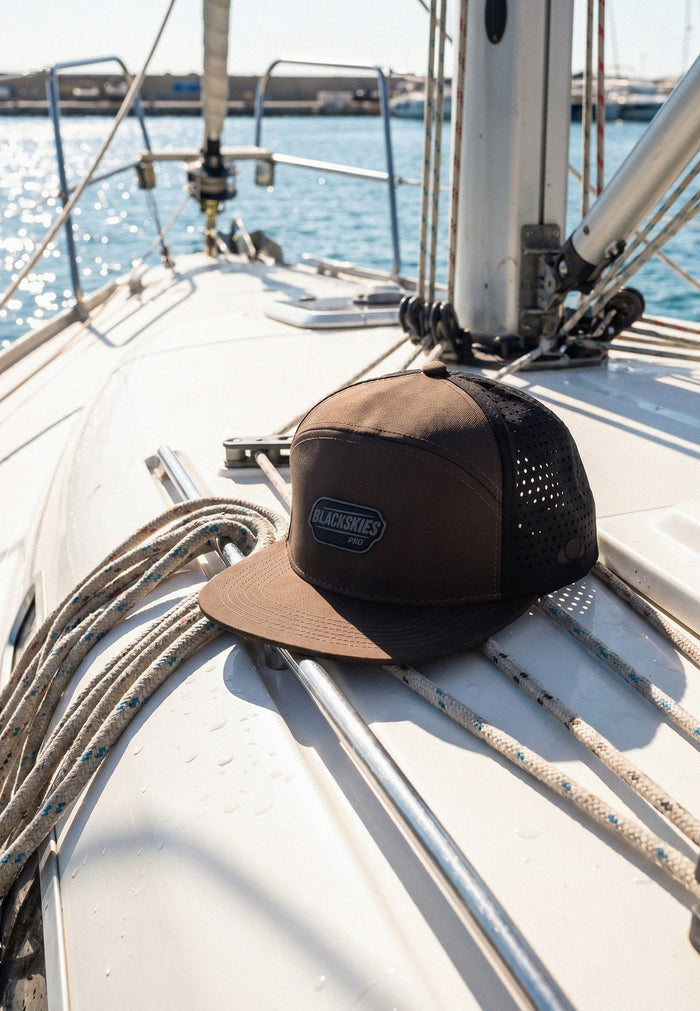 Brown and black cap on a sailboat with water in the background