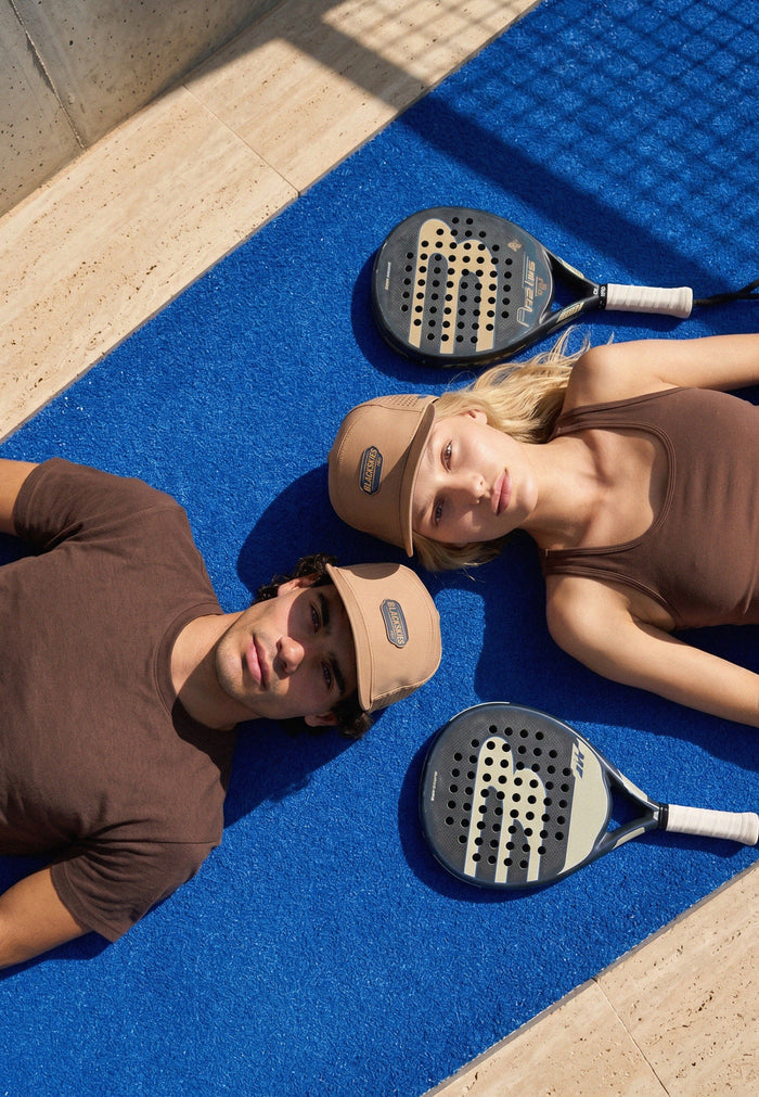Two people lying on a blue mat with paddle sports equipment