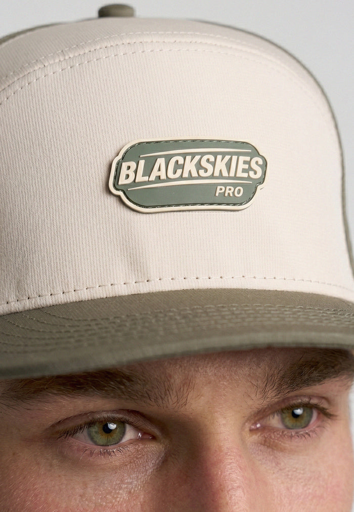 Beige cap with Blackskies Pro logo worn by a person