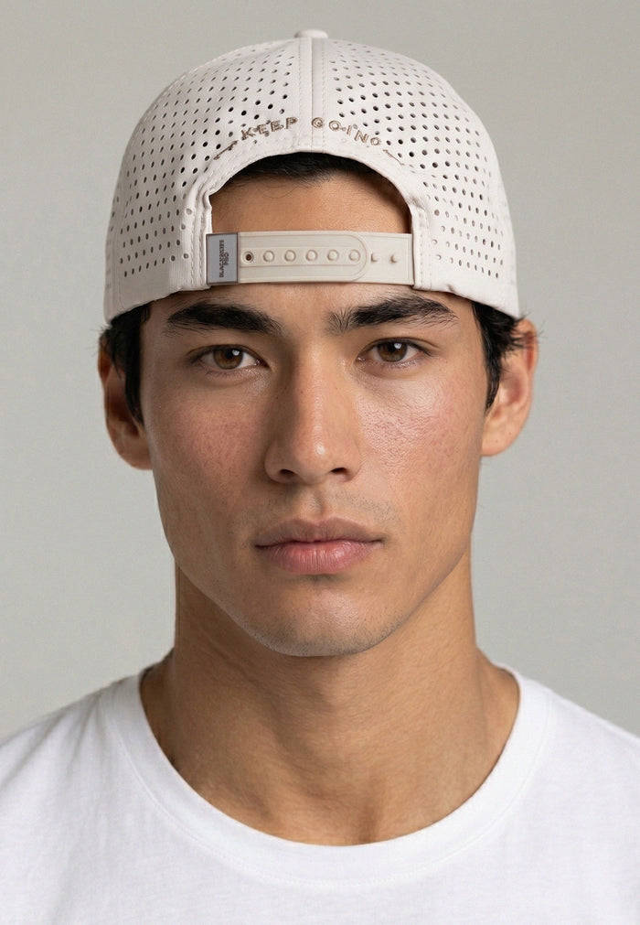 Man wearing a white cap with a gray background