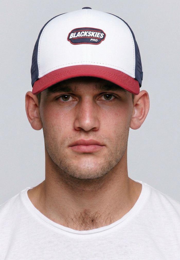 Man wearing a cap with 'Blackskies' logo on a plain background