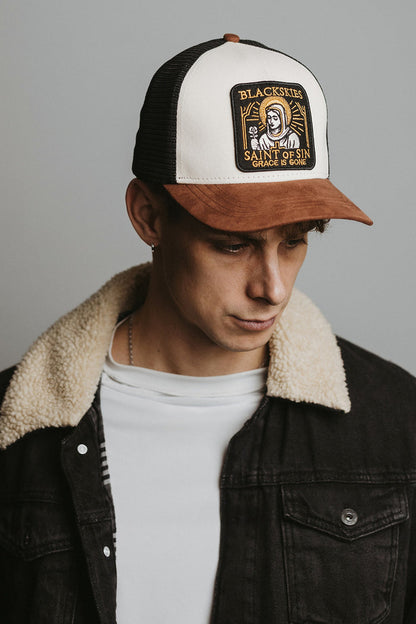 Person wearing a cap with a visible brand logo against a neutral background