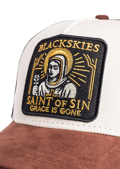 Brown and white cap with a Blackskies patch featuring a religious design.