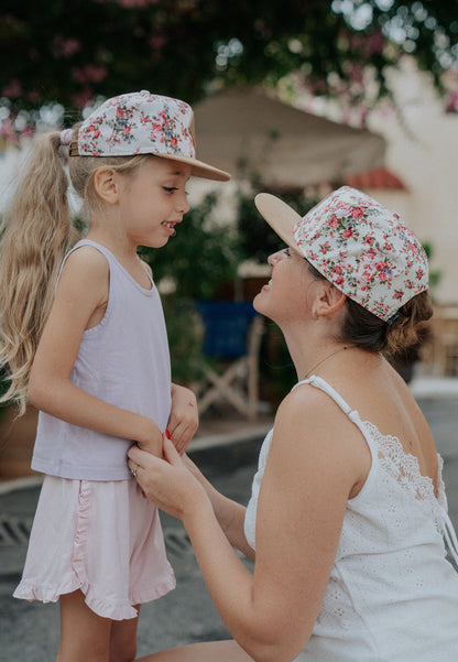 Woman and child wearing floral caps outdoors with blurred background