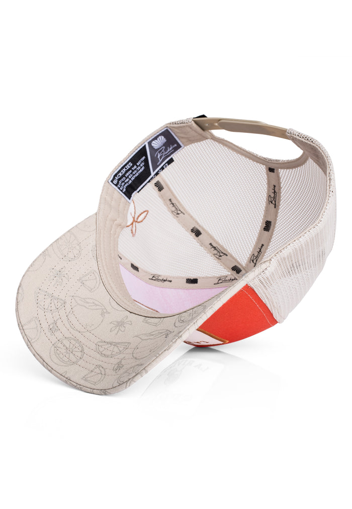 Beige and white cap with pink interior and red visor on a white background