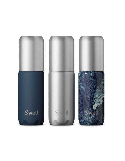 Set of three refillable aluminum travel bottles with leakproof pump, in navy blue, silver, and marbled blue design, with TSA compliant size