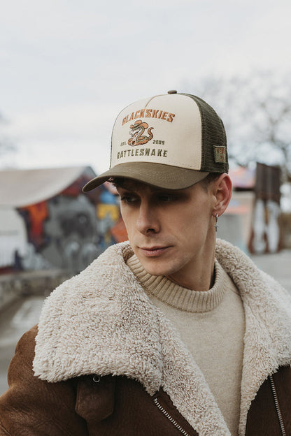 Man wearing a cap with 'Blackskies' branding in an outdoor setting